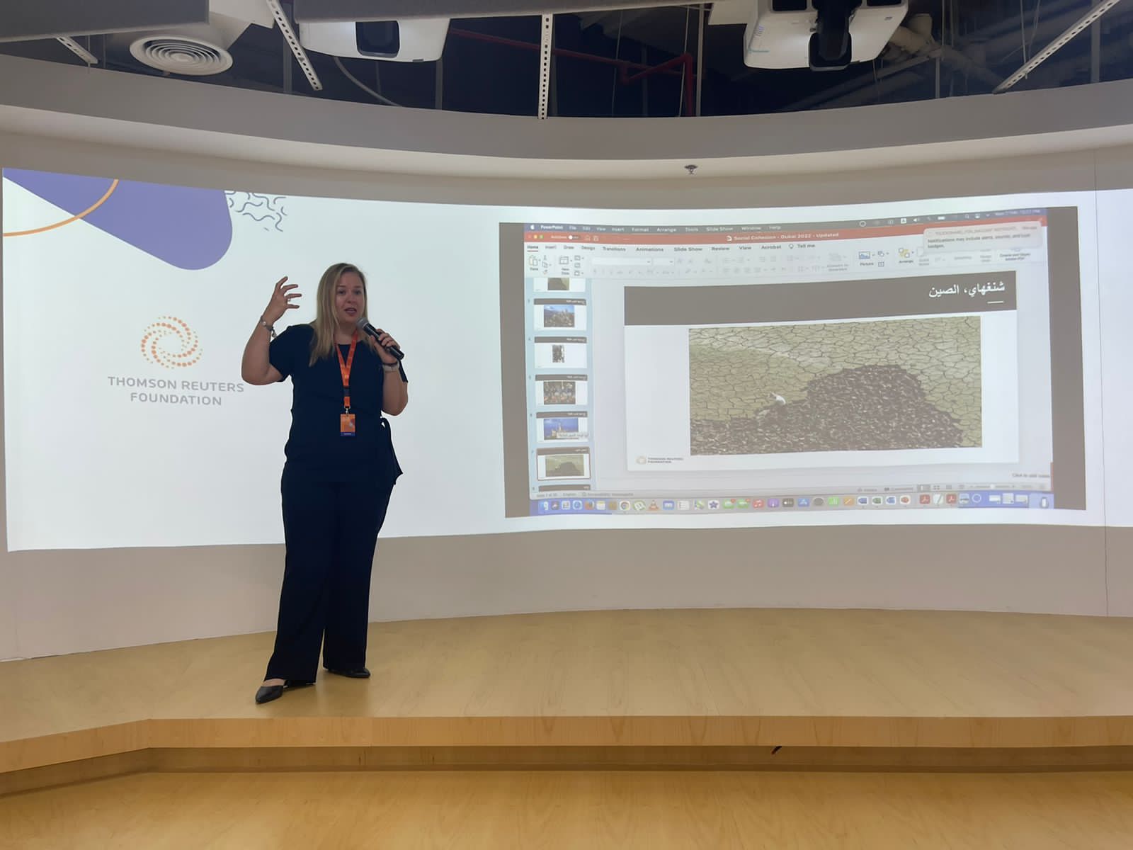 Sara El-Khalili presenting on stage at a Thomson Reuters Foundation event